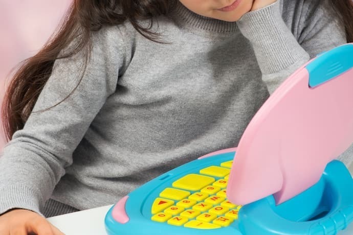 Menina brincando em laptop infantil 