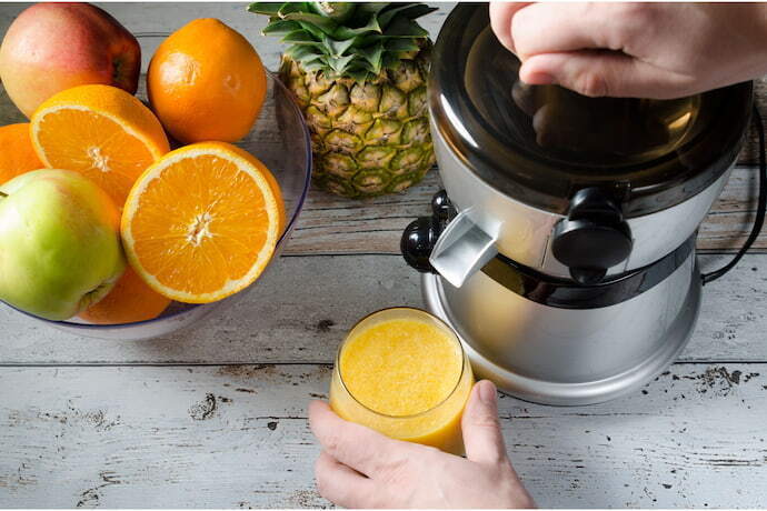 Pessoa fazendo suco na centrífuga de suco 