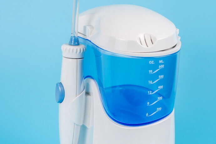 Irrigador dental branco e azul em fundo azul