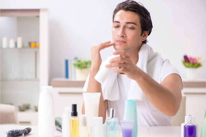 Homem com produtos de beleza e gel secativo para espinhas.