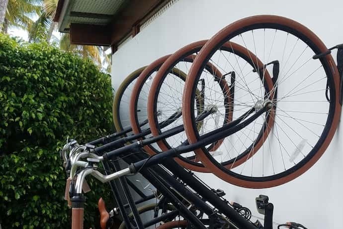 Várias bicicleta pendurada em parede por suporte.