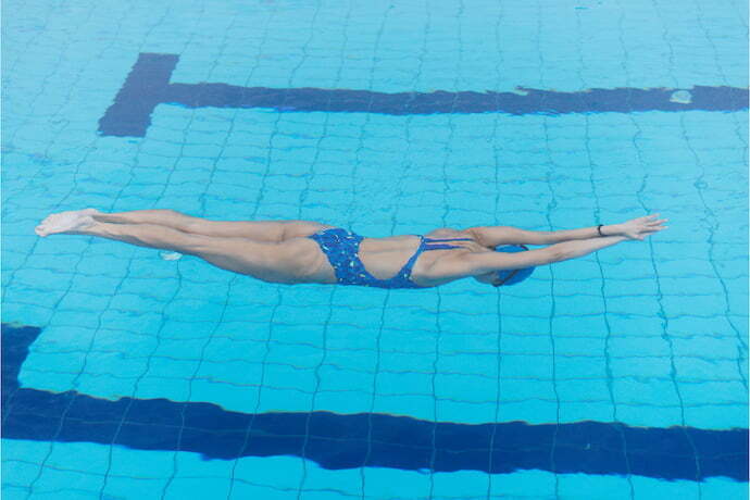 Nadadora na piscina usando maiô