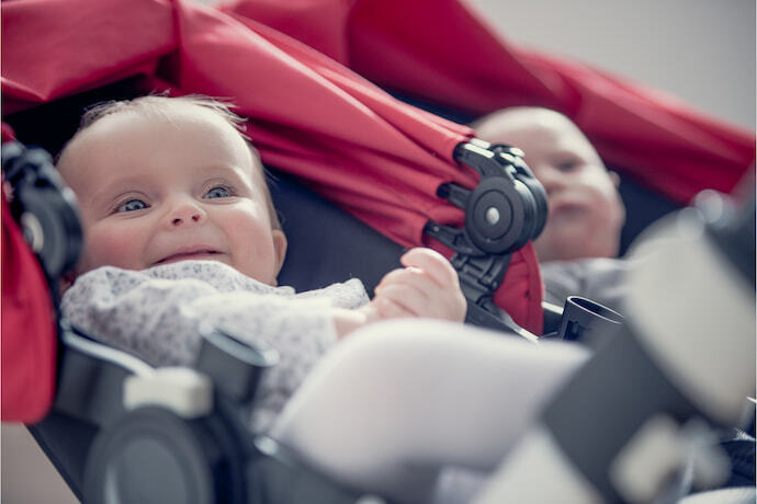 Gêmeos no carrinho de bebê para gêmeos