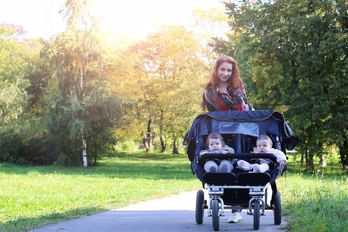 Gêmeos no carrinho de bebê para gêmeos