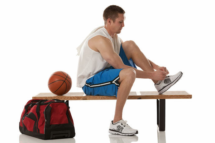 Atleta colocando tênis de basquete.