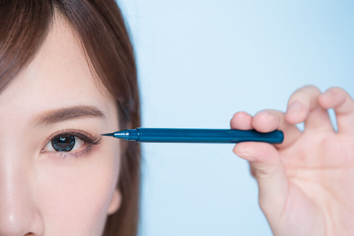 Mulher com caneta para sobrancelha azul