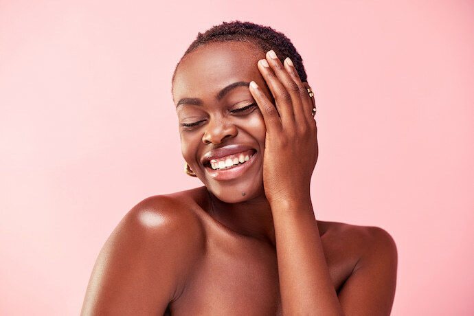 Mulher com pele negra iluminada sorrindo