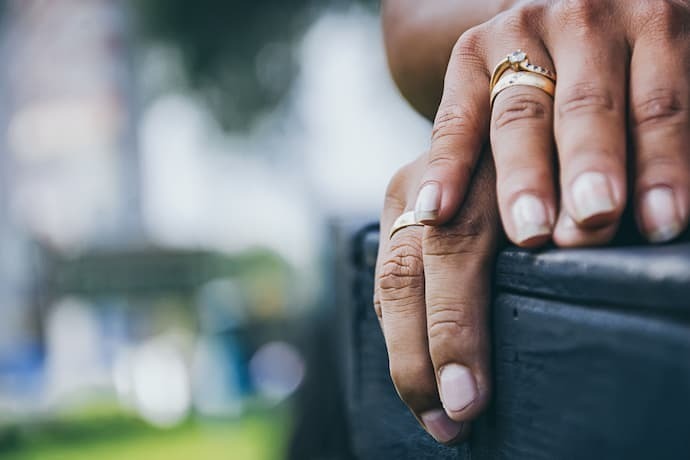 Casal com as mãos uma sobre a outra com alianças