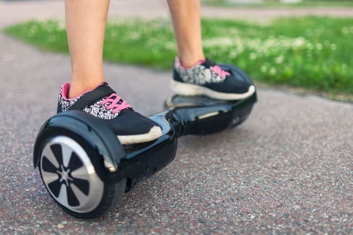 Menina andando em skate elétrico hoverboard preto. 