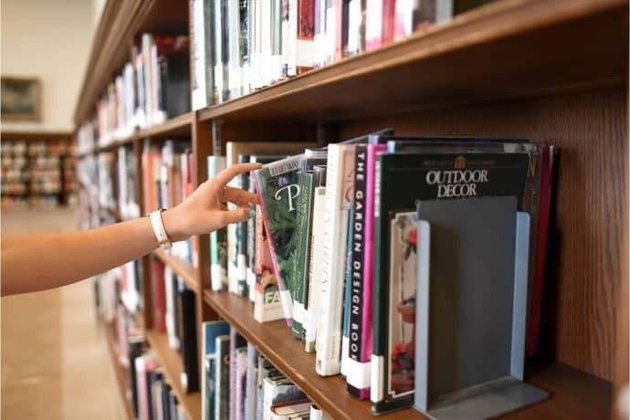 Mão feminina escolhendo livro