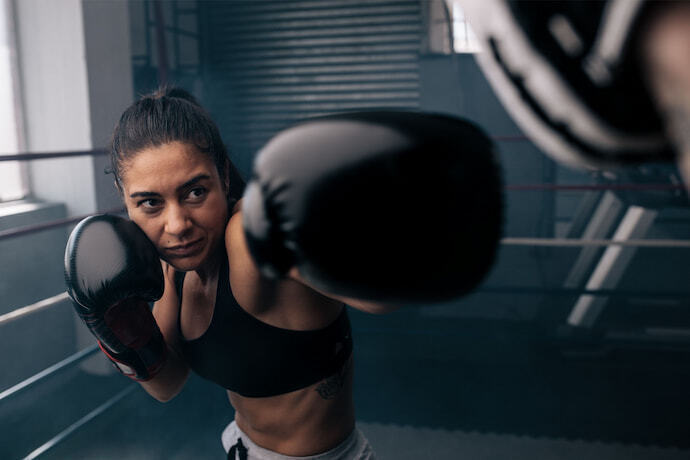 Mulher treinando com luva de boxe.