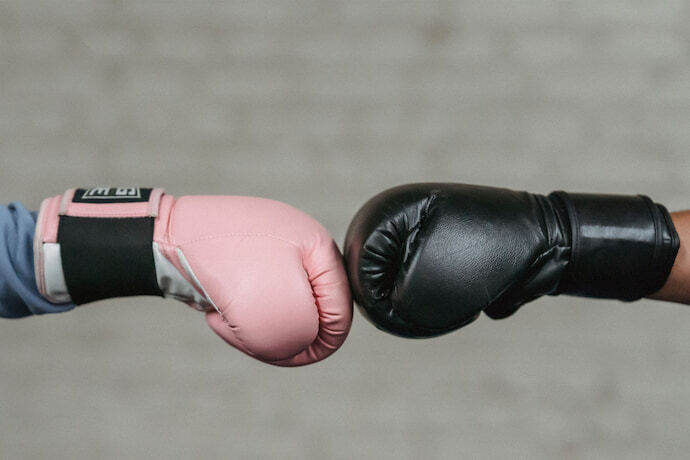 Pessoas tocando luvas de boxe.