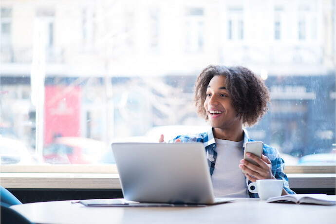 Menino feliz com notebook positivo.