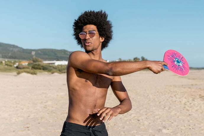 Homem jogando com raquete de Beach Tennis.