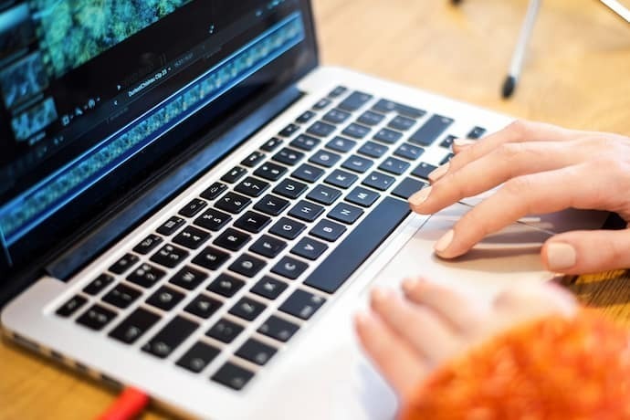 Pessoa mexendo em notebook para edição de vídeo.