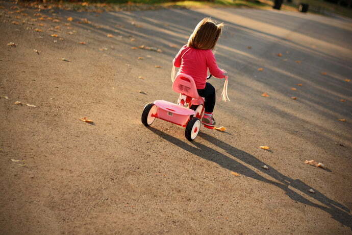 Criança brincando com triciclo infantil