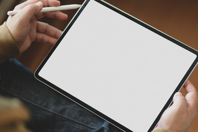 Homem segurando iPad branco com caneta