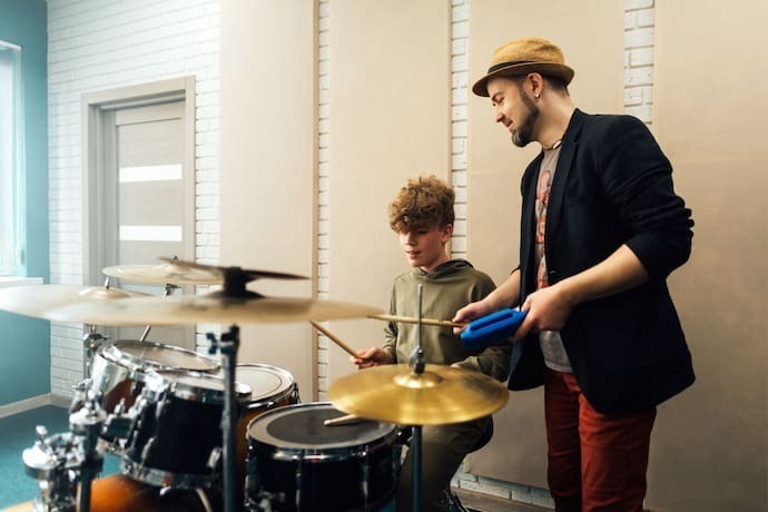 Amigos tocando bateria eletrônica.