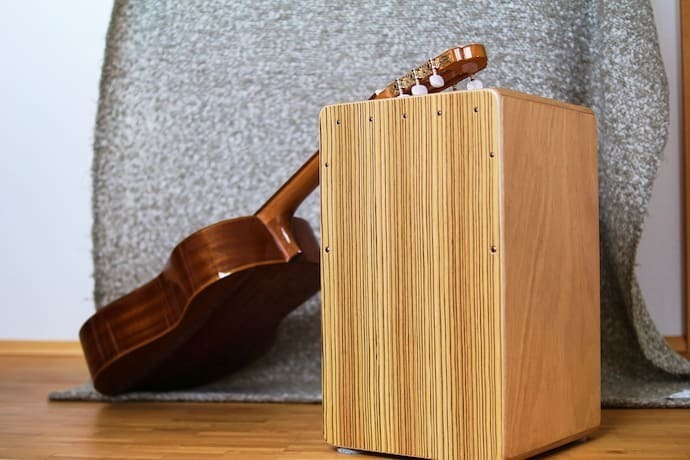 Cajon com violão apoiado.