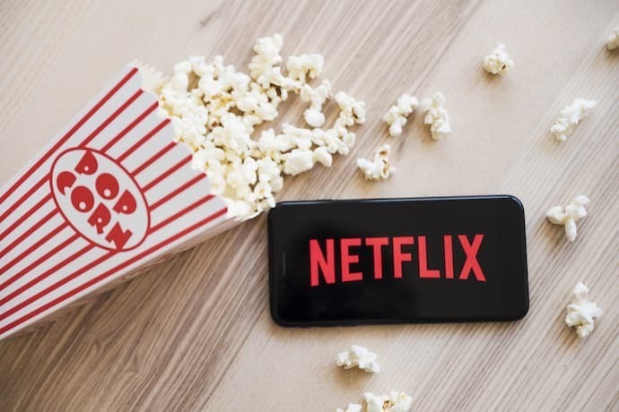 celular Xiaomi com netflix e pipoca ao redor