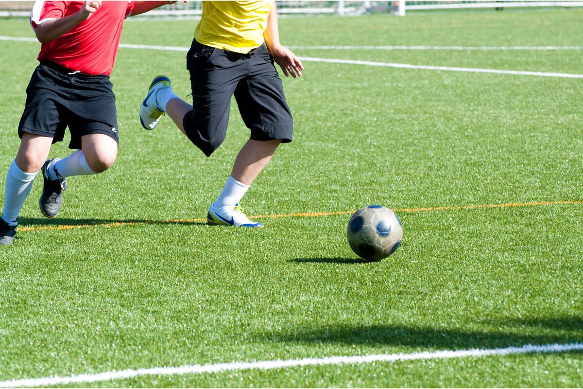 dois homens jogando futebol