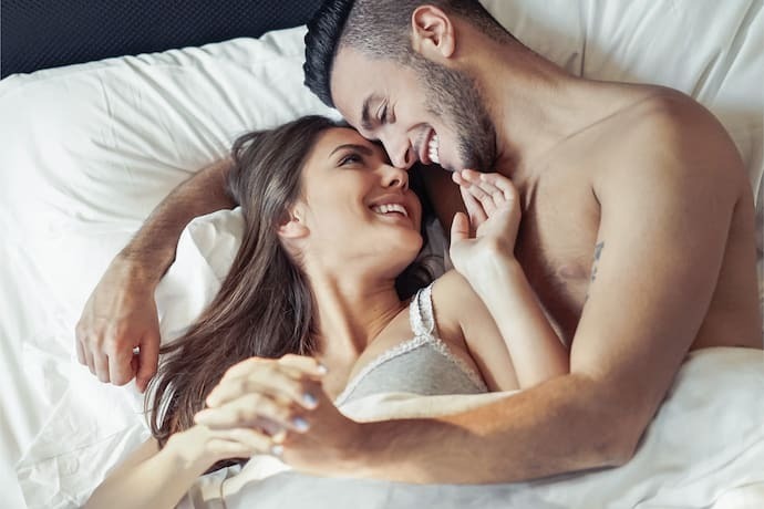 Casal de mãos dadas na cama