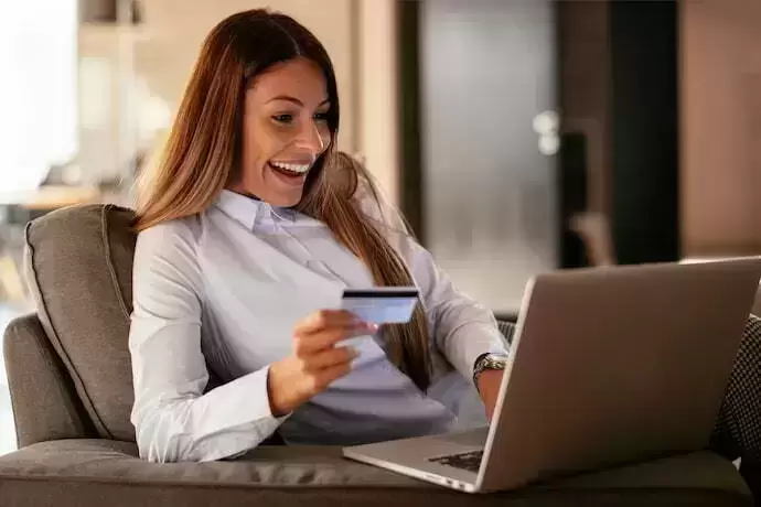 Mulher com cartão usando o notebook