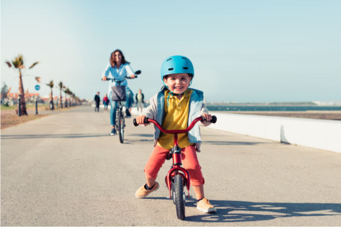 Criança andando de bicicleta com a mãe