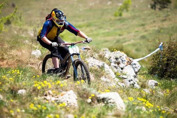 Ciclista andando de Mountain Bike em terreno acidentado