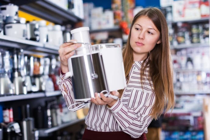 Mulher em busca de um processador de alimentos em uma loja de utensílios de cozinha.