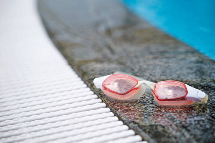 Óculos de natação na borda da piscina 