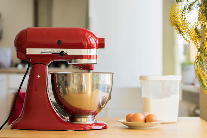 Cozinha com uma batedeira vermelha sobre a mesa.