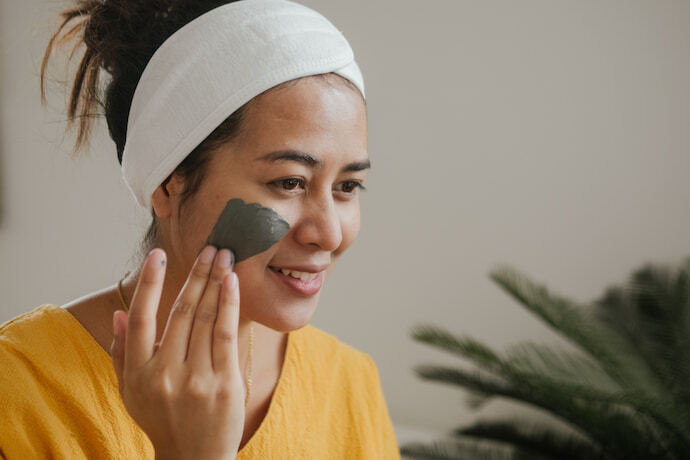 Mulher fazendo tratamento de beleza em casa com esfoliante.