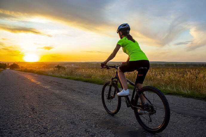 Moça andando de bicicleta no amanhecer