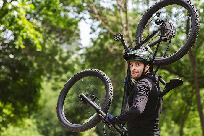 Homem carregando sua bicicleta