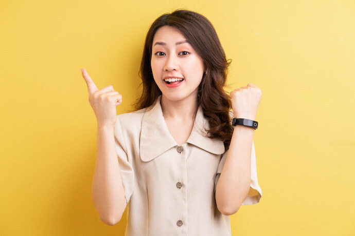 Mulher sorrindo e com um smartband no pulso