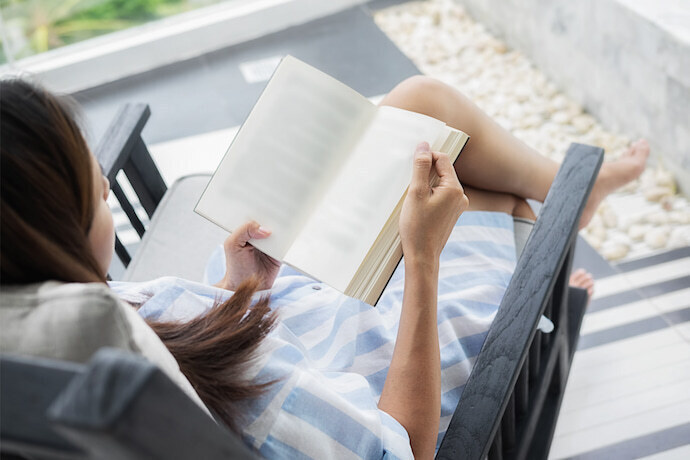 Mulher ao ar livre lendo um livro.