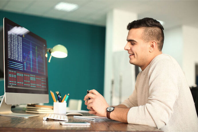 Homem trabalhando com grande monitor 