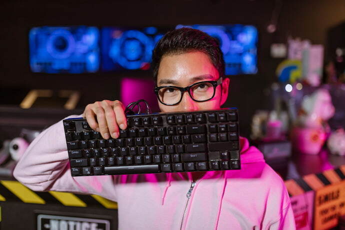 Homem mostrando o teclado gamer.