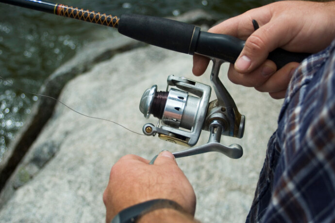 Homem usando uma carretilha de pesca