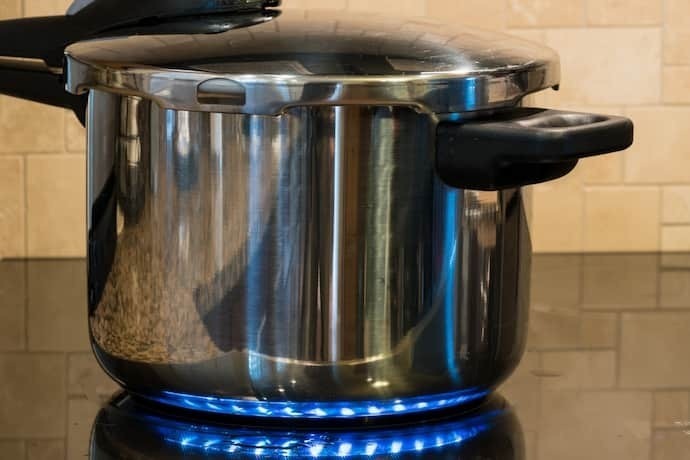 Panela de pressão no fogão cozinhando alguma coisa