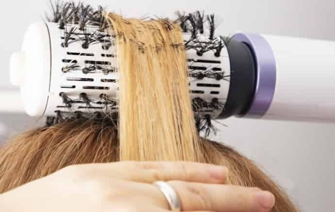 Alisando cabelo com escova secadora 