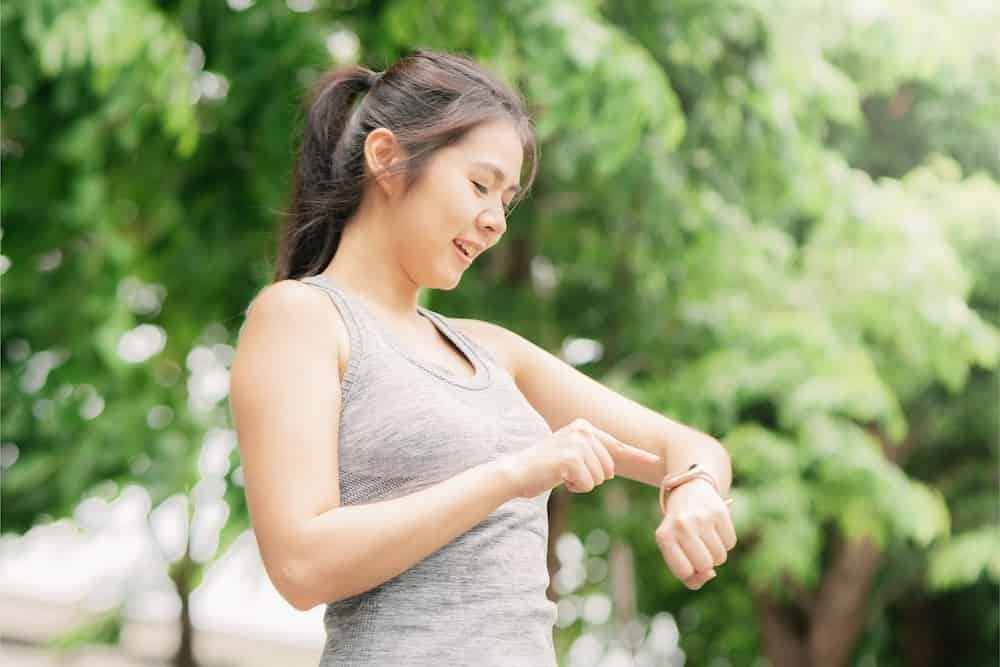 Mulher corredora utilizando relógio 