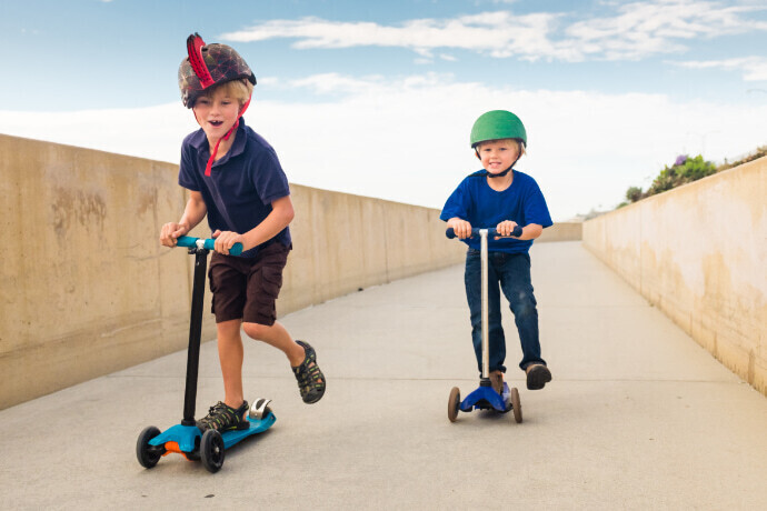 Duas crianças com patinetes