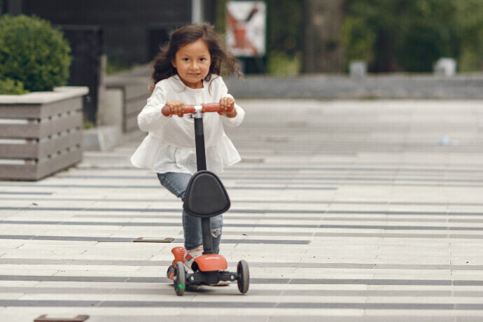 Menina andando de patinete no parque