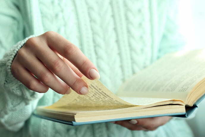 Mulher foleando páginas de livro 