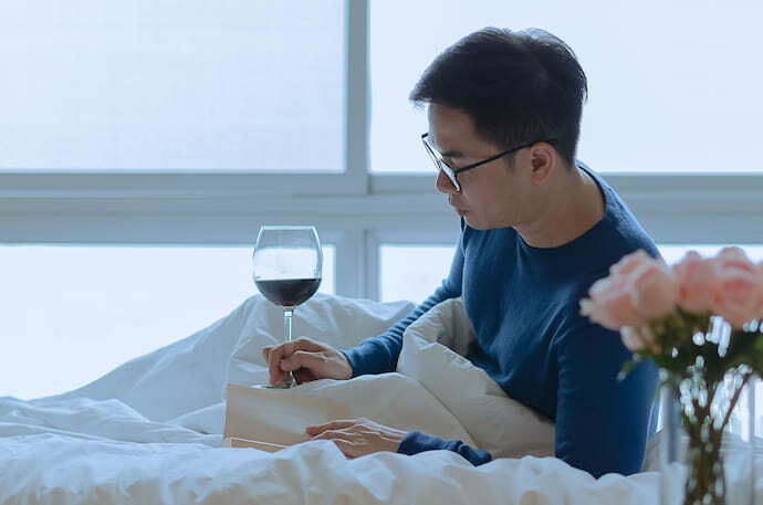 Homem lendo livro na cama