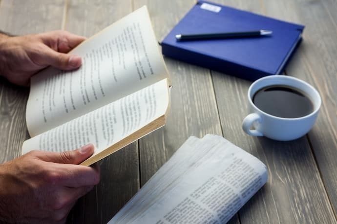 Pessoa lendo livro na mesa