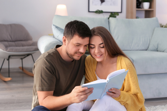 Dois indivíduos lendo um livro