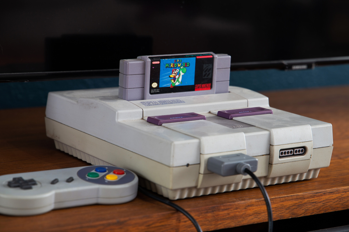 Super Nintendo com o jogo do Super Mario Bros na frente da TV